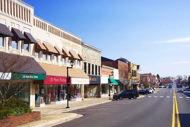 A row of East Main Street shops in Lincolnton with striped awnings, lamp posts and a long view down the street